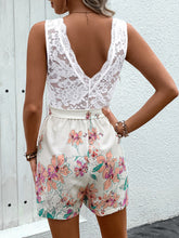 Model showing back view of romper with delicate back tie detail, soft lace top, and flowing floral bottom, highlighting a graceful, feminine silhouette.