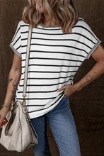 Model wearing striped knit round neck short sleeve top, front view in white and black stripes, paired with denim jeans.