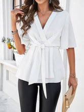 White Tied Front Peplum Blouse styled with tan handbag black leather pants, accessories, and heels.