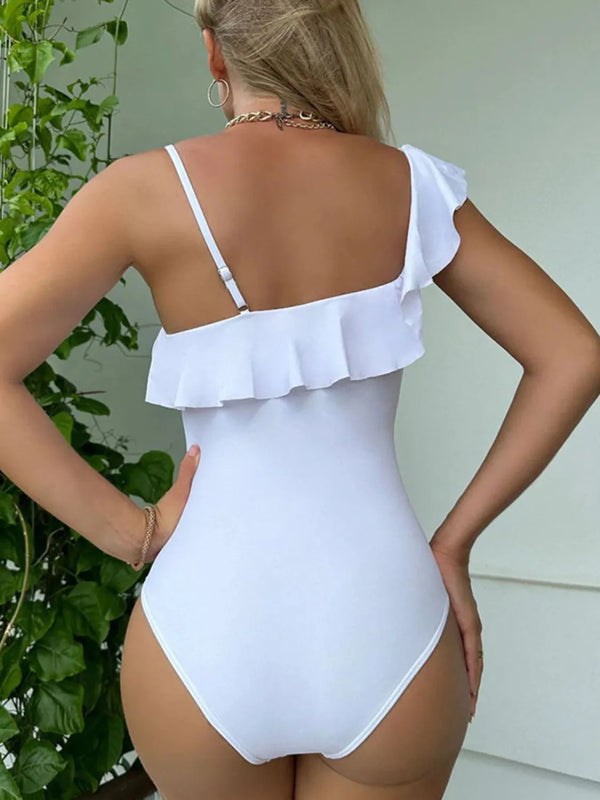 Back view detail of white asymmetrical ruffled one-piece swimsuit showing adjustable strap and back coverage
