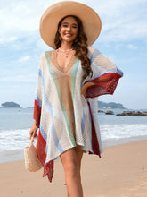 Model wearing white openwork color block plunge cover-up with deep V-neckline at beachside setting
