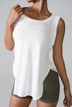 Woman in White slit round neck active tank top styled with dark gray biker shorts.