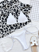 Front flat lay of white textured halter neck tie side bikini set with gold O-ring details and adjustable straps