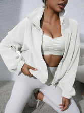 white turtleneck zip up jacket stretching pose