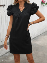 Woman modeling the Calivémuse™ Black Ruffled Notched Cap Sleeve Mini Dress styled with accessories. 