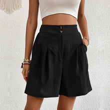 Model wearing women's black partial elastic high waist pleated baggy trouser shorts.