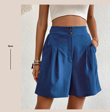 Women's blue partial elastic high waist pleated baggy trouser shorts, front view.