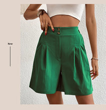 Model wearing women's dark green partial elastic high waist pleated baggy trouser shorts.