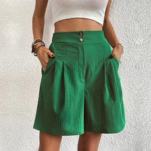 Women's dark green partial elastic high waist pleated baggy trouser shorts, front view.