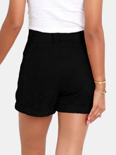 Female showcasing the back side of a pair of Black Metropolitan Maven High-Waist Shorts paired with a white tank top and jewelry.