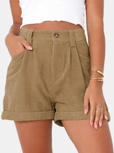 Female modeling the Camel Metropolitan Maven High-Waist Shorts paired with a white tank top and jewelry.