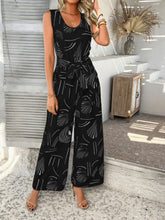 Black Zauraphina jumpsuit styled with a denim jacket and sneakers for a casual look.