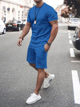 Front walking view of men’s blue Zavren EaseForm Set with cuffed sleeves and stitched shorts.