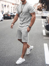 Front walking view of men’s dark gray Zavren EaseForm Set with cuffed sleeves and stitched shorts.