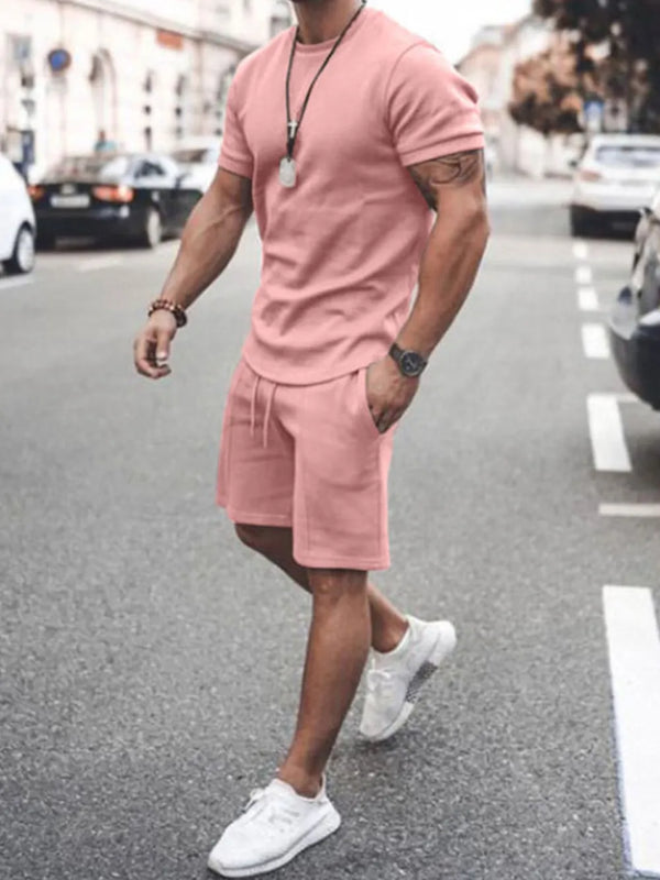 Front walking view of men’s dusty pink Zavren EaseForm Set with cuffed sleeves and stitched shorts.