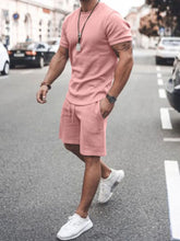 Front walking view of men’s dusty pink Zavren EaseForm Set with cuffed sleeves and stitched shorts.