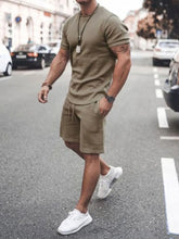 Front walking view of men’s khaki Zavren EaseForm Set with cuffed sleeves and stitched shorts.