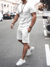 Front walking view of men’s white Zavren EaseForm Set with cuffed sleeves and stitched shorts.