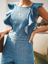 Close-up of the Zelisse Denim Jumpsuit in medium blue, showcasing the delicate ruffled cap sleeves, round neckline, and soft, high-quality denim fabric texture on a model.