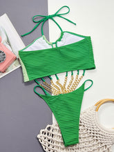 Flat lay back view of the Zelvaya Contrast Chain Halter Swimsuit highlighting open back and contrast detailing.