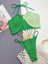 Flat lay front view of the Zelvaya Contrast Chain Halter Swimsuit showing chain detail and contrast color design.