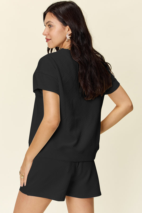 Back view of model in black Zero Lies Zone lounge set with relaxed fit and drop-shoulder sleeves.