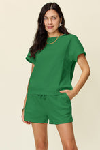 Model in green Zero Lies Zone set paired with platform slides for laid-back afternoons and patio hangs.