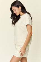 Model side view of a ivory Zero Lies Zone Texture Short Sleeve Top and Drawstring Shorts Set paired with gold jewelry and platform sneakers.