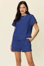 Model styled in royal blue Zero Lies Zone set with classic sneakers and a crossbody bag for city strolls.