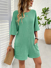Zoomed in front profile of green romper with textured stripe detail.